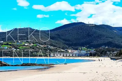 a view of a beach with a mountain in the background at Ribeira in Vivero
