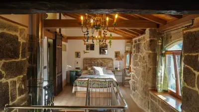 a bedroom with a bed and a stone wall at Casa la Trinidad - Ribeira Sacra in Nogueira de Ramuin