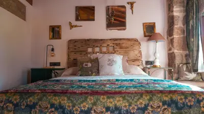 a bedroom with a bed with a colorful bedspread at Casa la Trinidad - Ribeira Sacra in Nogueira de Ramuin