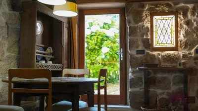 a dining room with a table and chairs and a window at Casa la Trinidad - Ribeira Sacra in Nogueira de Ramuin