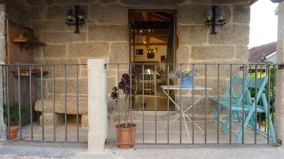 a porch with a gate and a table and a chair at Casa la Trinidad - Ribeira Sacra in Nogueira de Ramuin