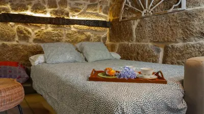 a bedroom with a bed with a tray with a cup on it at Casa la Trinidad - Ribeira Sacra in Nogueira de Ramuin