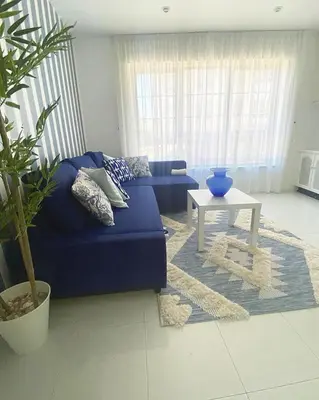 a living room with a blue couch and a table at Apartamento San Roque in Betanzos