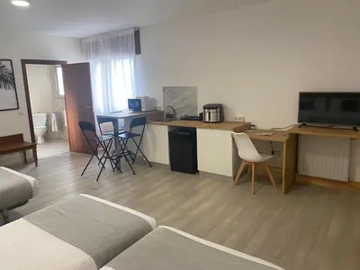 a room with a bed and a kitchen with a table at Alda Cabanas Playa in Cabañas