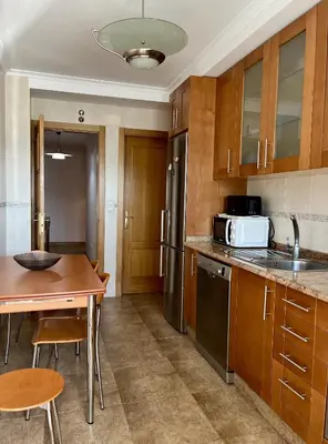 a kitchen with wooden cabinets and a table and a microwave at Preciosas vistas en el corazón de la Riveira Sacra in Quiroga