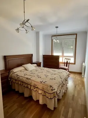 a bedroom with a bed and a chair and a window at Preciosas vistas en el corazón de la Riveira Sacra in Quiroga