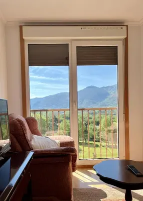 a living room with a couch and a large window at Preciosas vistas en el corazón de la Riveira Sacra in Quiroga