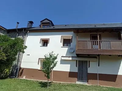 a white house with a balcony and a yard at Casa rural La Barriada de Lago de Carucedo in Lago de Carucedo