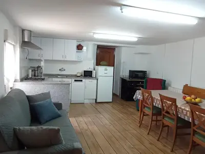 a kitchen and living room with a couch and a table at Casa rural La Barriada de Lago de Carucedo in Lago de Carucedo