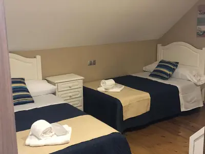 a room with three beds with towels on them at A Casa de Abaixo in Cuntis