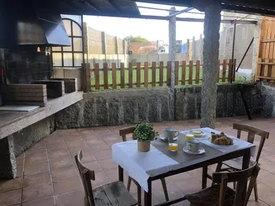 a white table and chairs on a patio at A Casa de Abaixo in Cuntis