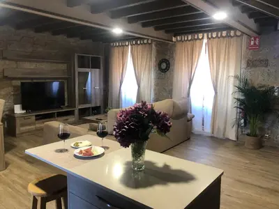 a living room with a table with a vase of flowers at A Casa de Abaixo in Cuntis