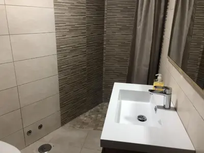 a bathroom with a white sink and a shower at A Casa de Abaixo in Cuntis