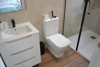 a bathroom with a white toilet and a sink at Greco 8 in Sarria