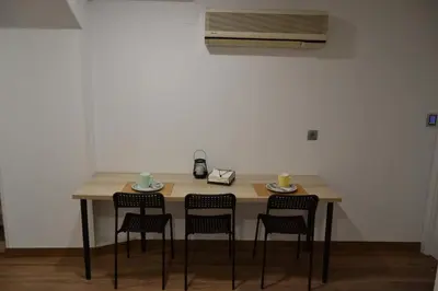 a table with four chairs and two cups and a phone at Greco 8 in Sarria