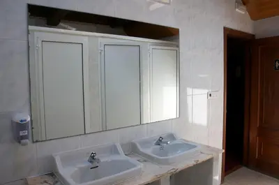 a bathroom with two sinks and a mirror at Albergue los Blasones in Sarria