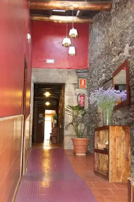 a hallway of a building with red walls at Albergue los Blasones in Sarria