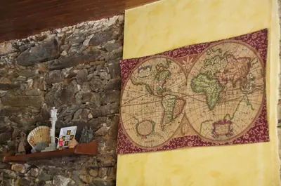 a map of the world hanging on a stone wall at Albergue los Blasones in Sarria