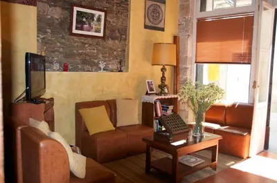 a living room with a couch and a tv at Albergue los Blasones in Sarria