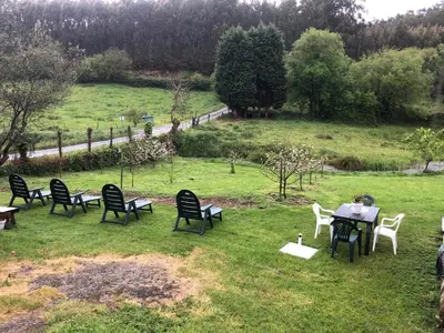 a group of chairs and tables in a field at Casa de Campo Pumarada de Oirín in Foz