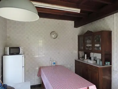 a kitchen with a table and a refrigerator at Casa de Campo Pumarada de Oirín in Foz