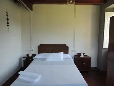 a bedroom with a large bed with two night stands at Casa de Campo Pumarada de Oirín in Foz