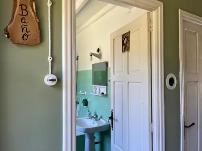 a small bathroom with a sink and a mirror at Casa de Campo Pumarada de Oirín in Foz