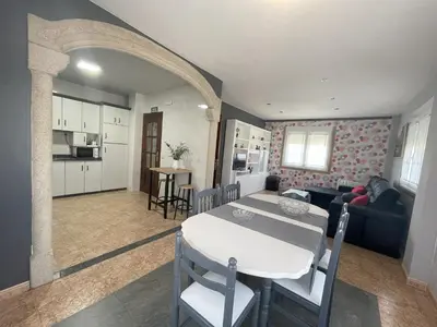 a kitchen and living room with a table and a dining room at Toxiños Lavacolla in A Coruña