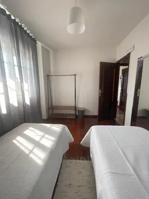 a bedroom with two beds and a window at Toxiños Lavacolla in A Coruña