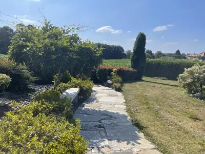 a path in a garden with bushes and trees at Toxiños Lavacolla in A Coruña
