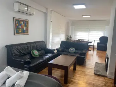 a living room with two leather couches and a table at Magnífica casa independiente by beBalmy in Santiago de Compostela