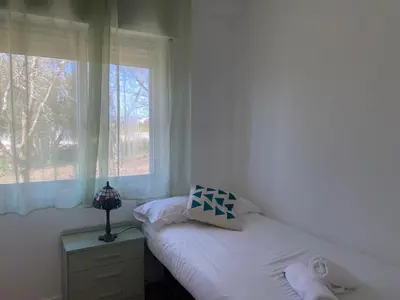 a white bedroom with a bed and a window at Magnífica casa independiente by beBalmy in Santiago de Compostela