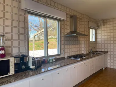 a kitchen with a counter with a sink and a window at Magnífica casa independiente by beBalmy in Santiago de Compostela