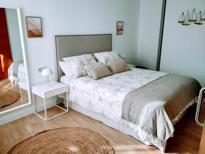 a bedroom with a large bed and a mirror at Apartamento en Sada con Piscina in Sada