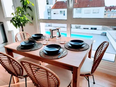 a wooden table with four chairs and a table with hats and glasses at Apartamento en Sada con Piscina in Sada