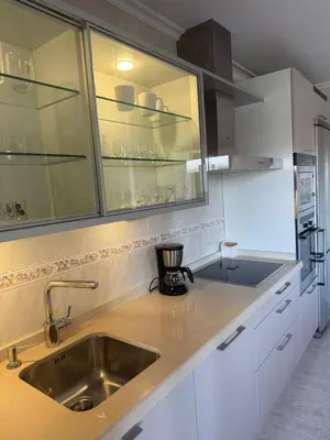 a kitchen with white cabinets and a sink at Apartamento moderno en Valga ideal para peregrinos y familias, junto al Camino de Santiago in Pontevedra
