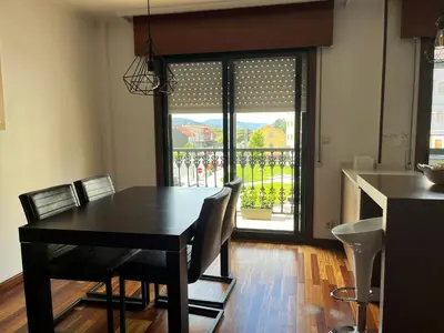a dining room with a table and chairs and a window at Apartamento moderno en Valga ideal para peregrinos y familias, junto al Camino de Santiago in Pontevedra