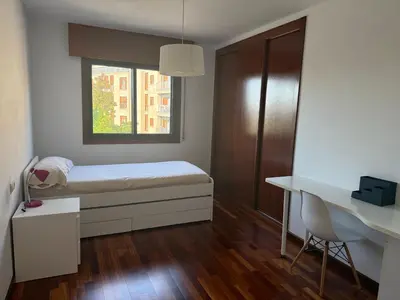 a bedroom with a bed and a desk and a window at Apartamento moderno en Valga ideal para peregrinos y familias, junto al Camino de Santiago in Pontevedra