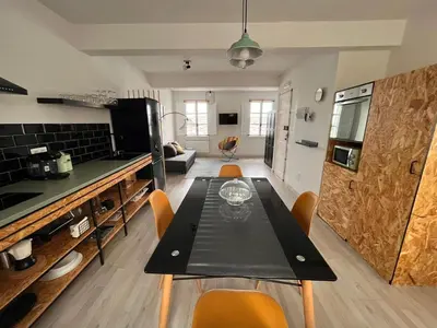 a kitchen with a table and chairs in a room at Apartamentos Ribadeo in Ribadeo