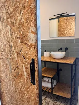 a bathroom with a shower door with a sink at Apartamentos Ribadeo in Ribadeo