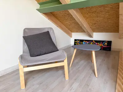 a chair and a table in a room at Apartamentos Ribadeo in Ribadeo