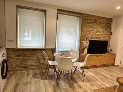 a dining room with a table and chairs and a tv at Casa Bela I Apart Lux Santiago in Santiago de Compostela
