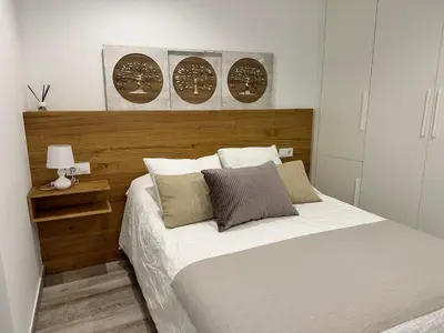 a bedroom with a large bed with a wooden headboard at Casa Bela I Apart Lux Santiago in Santiago de Compostela