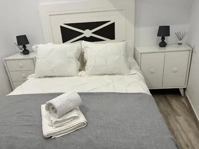 a white bed with white pillows and towels on it at Casa Bela I Apart Lux Santiago in Santiago de Compostela