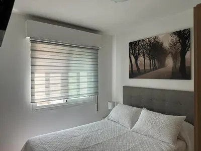 a bedroom with a bed and a window with blinds at Ensino 22 in Ourense