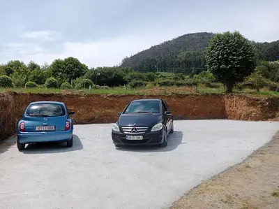 two cars are parked in a parking lot at Casa Lolita 2 in Viveiro