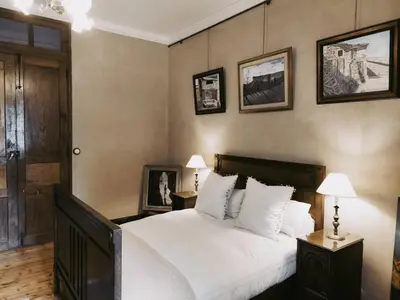 a bedroom with a large white bed and pictures on the wall at Santa Emilia in Mondoñedo