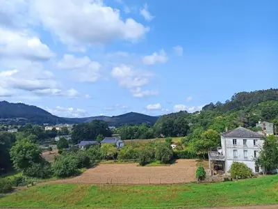 an old house on a hill with a field at Santa Emilia in Mondoñedo