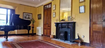 a living room with a piano and a fireplace at Santa Emilia in Mondoñedo