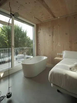 a bedroom with a tub and a bed and a window at Hotel Amiuka in O Pedrouzo